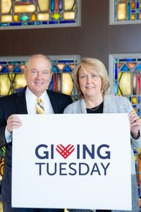 Patrick and Laurie hold Giving Tuesday sign