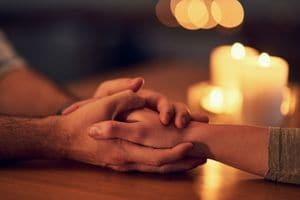 holding hands next to candle