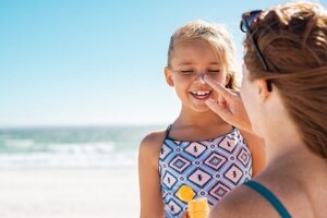 mother putting sunscreen on child