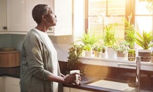 Older woman looking out the kitchen window